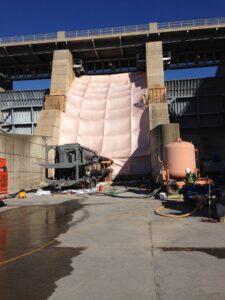 A dam under construction using using a large inflatable cofferdam - temporary water barrier.